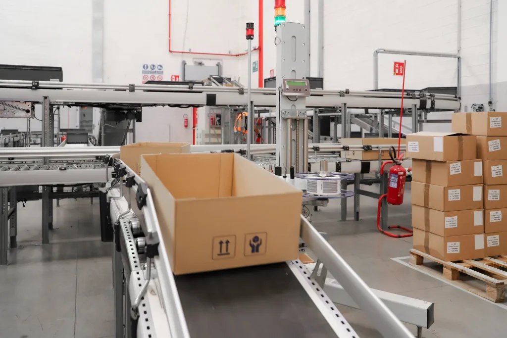 Cinta transportadora automatizada con cajas de cartón en un almacén