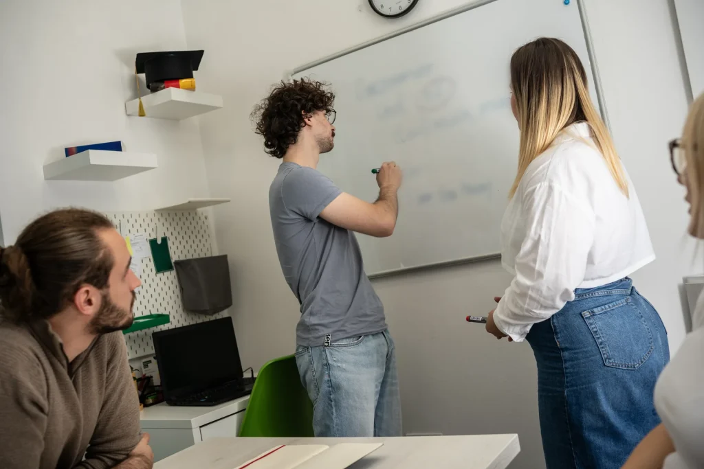 Alumnos y profesora repasando una lección en la pizarra de una academia de idiomas